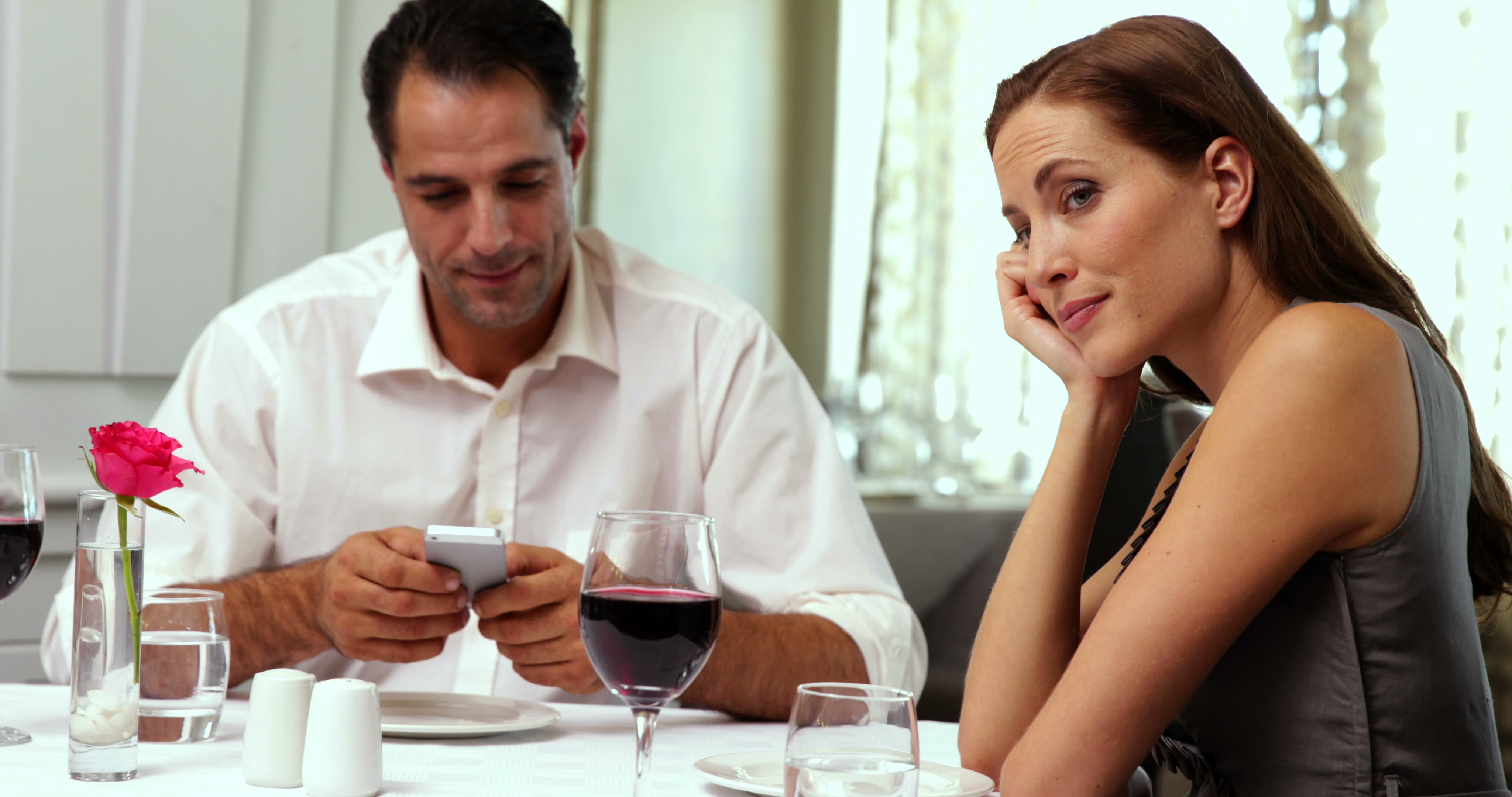 📱 Reply to These Texts and We’ll Reveal How Easily Annoyed You Are stock footage bored woman waiting for her date to stop texting at a restaurant