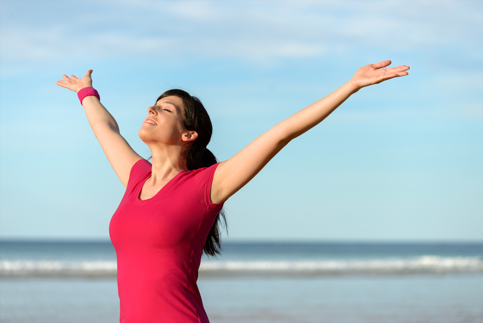 Happy fitness woman raising arms