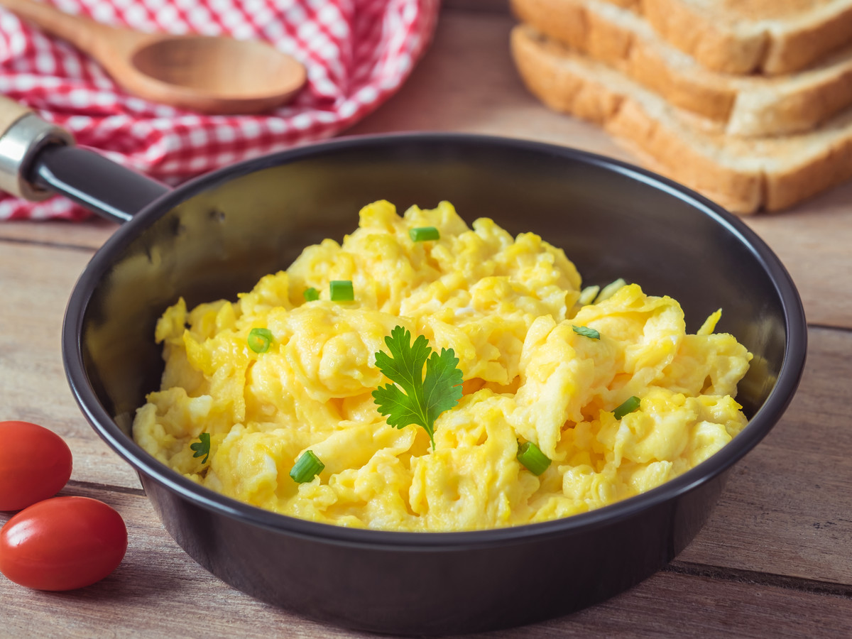 🧀 Put Cheese on These Foods and We’ll Reveal How Tall You SHOULD Be Scrambled egg in frying pan and toast on wooden table