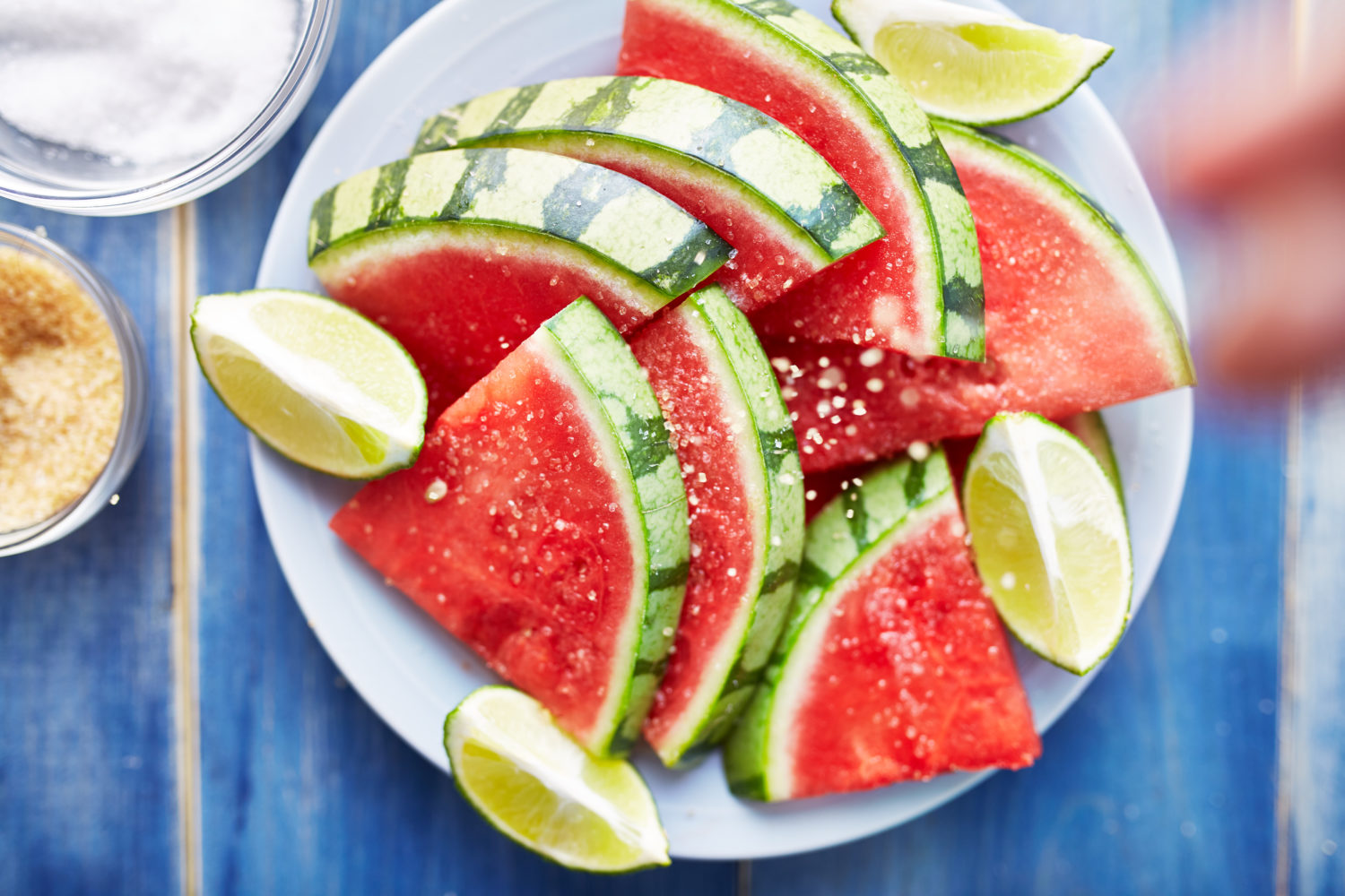 Settle These Food Debates and We’ll Guess Which Three Foods You Love the Most sprinkling salt on pile of watermelon slices