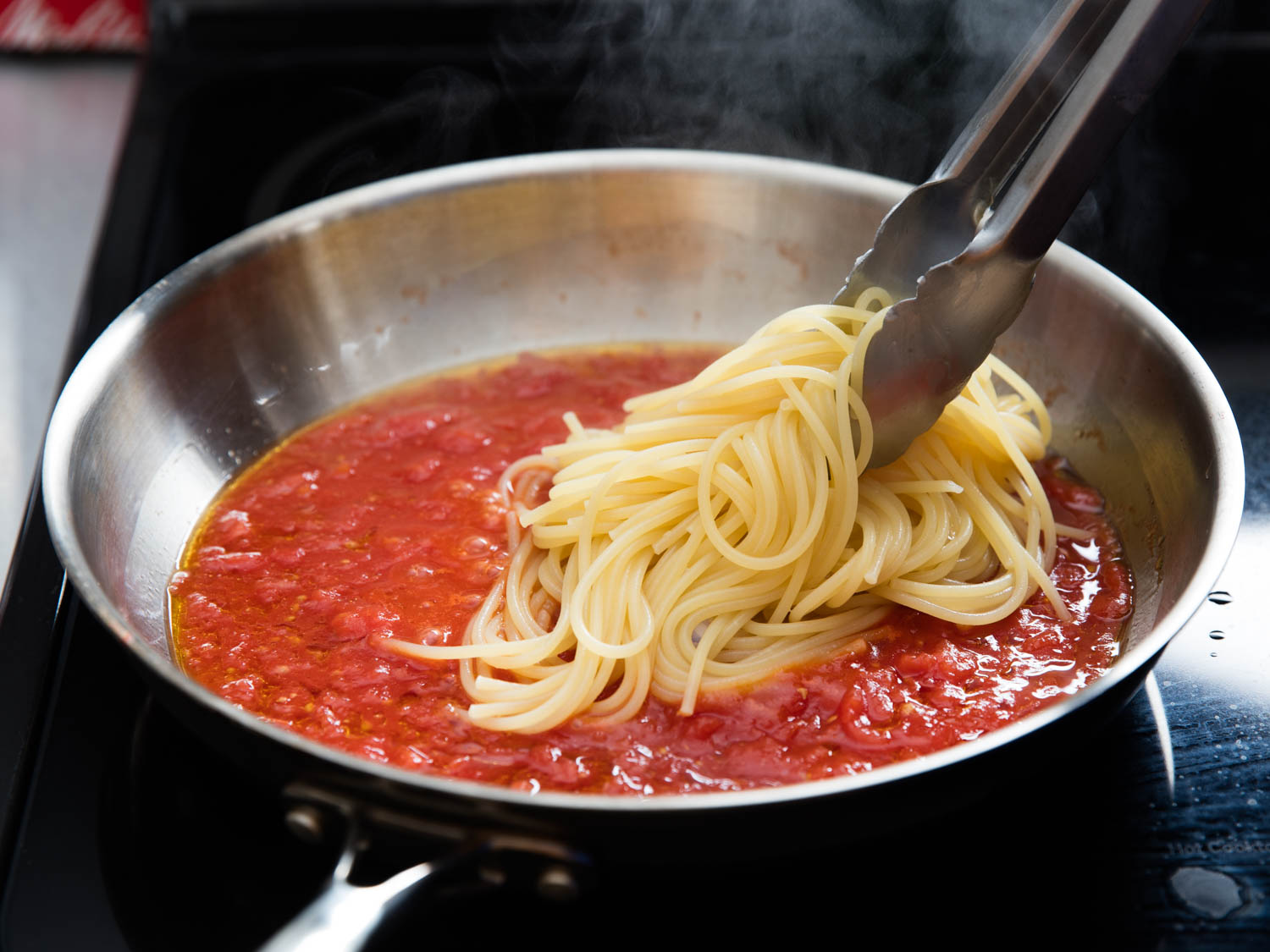 Settle These Food Debates and We’ll Guess Which Three Foods You Love the Most tossing pasta in sauce