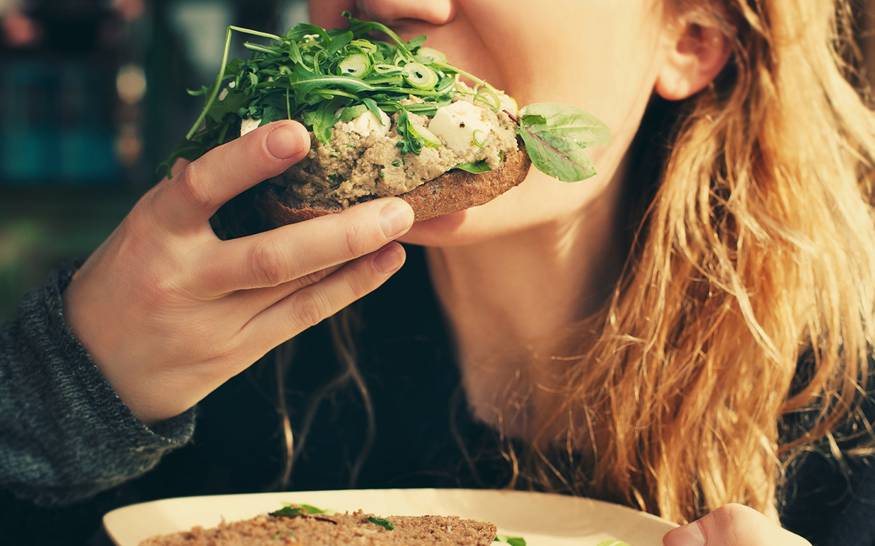 🍴 If You Eat 8/25 of These Foods With a Fork, You’re Forking Ridiculous Girl biting veggie sandwich.
