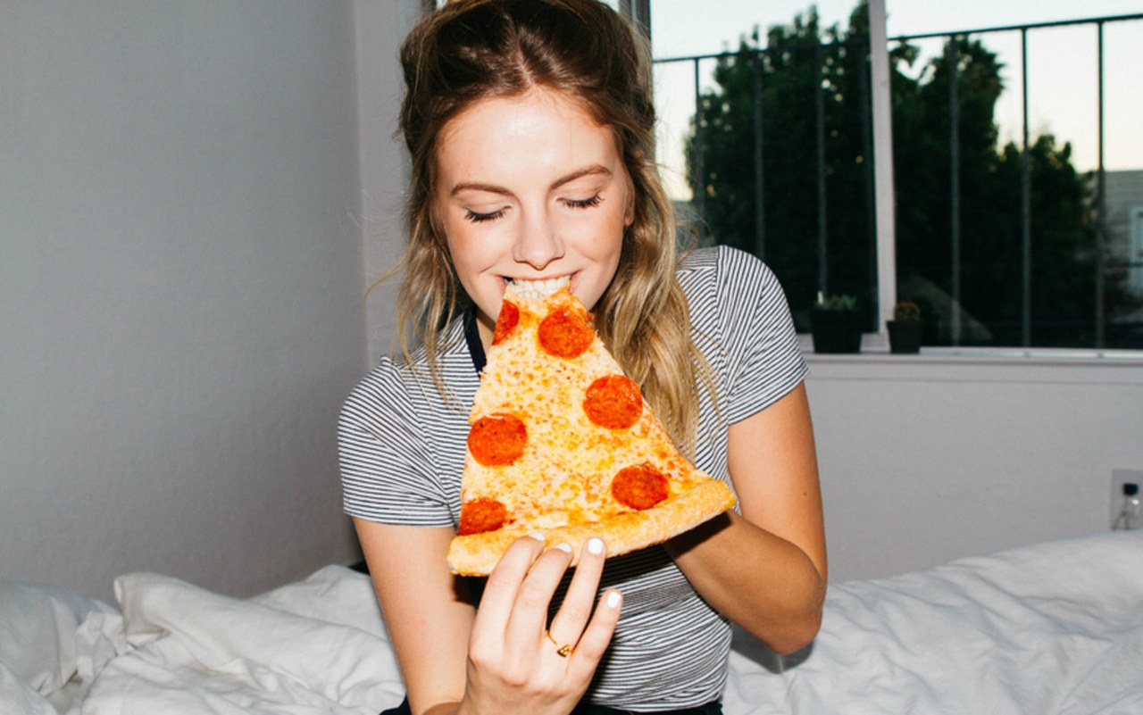 👶 Your Food Preferences Will Reveal Whether You’re a Youngest, Middle, Oldest, Or Only Child Woman Eating Pizza