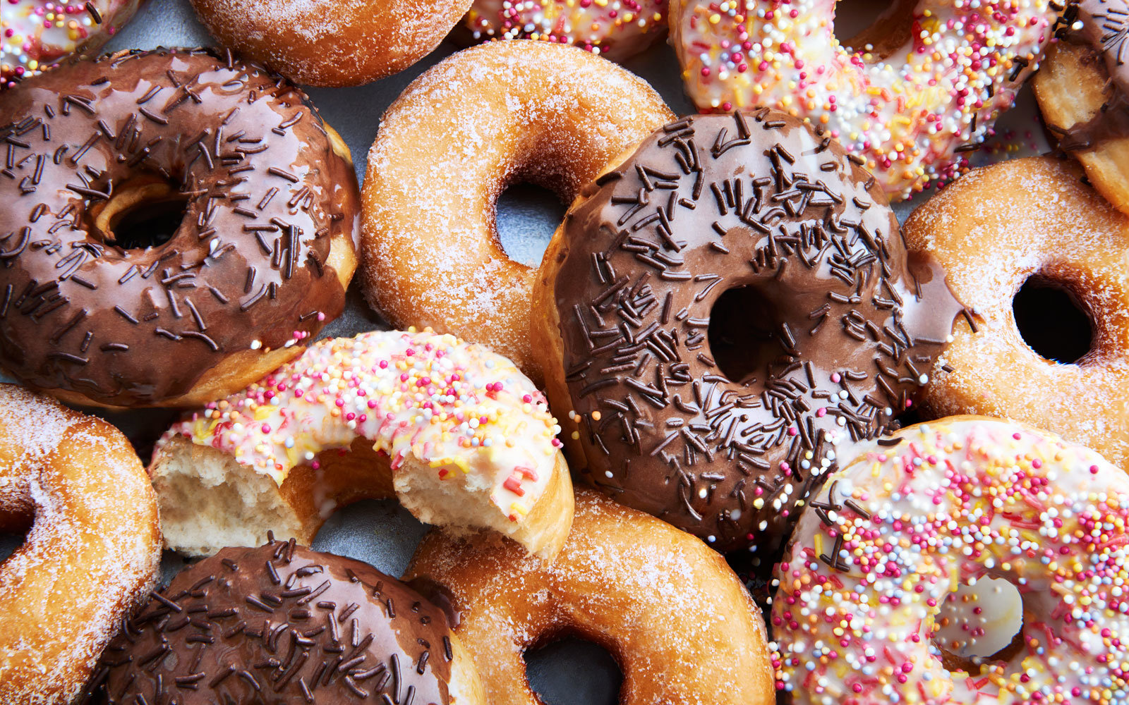 Rename These Common Foods to Find Out How Old You Are Inside Ring doughnuts covered in icing and sprinkes