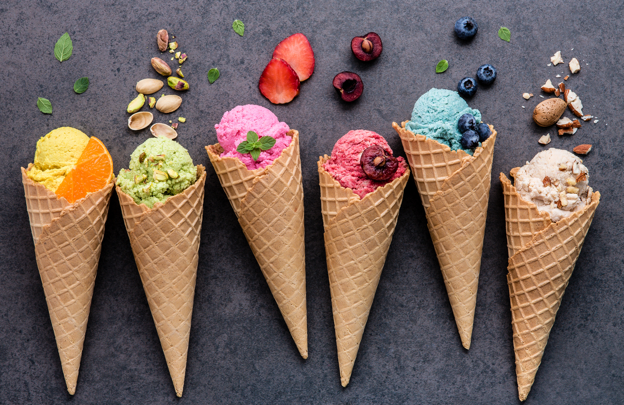 What Dessert Are You? Various of ice cream flavor in cones blueberry ,strawberry ,pistachio ,almond ,orange and cherry setup on dark stone background . Summer and Sweet menu concept.