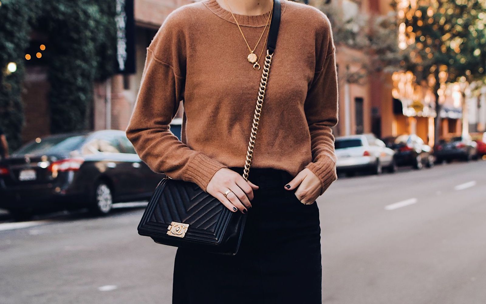 Put Together an All-Black Outfit and We’ll Reveal How Dark Your Soul Is woman wearing black bag