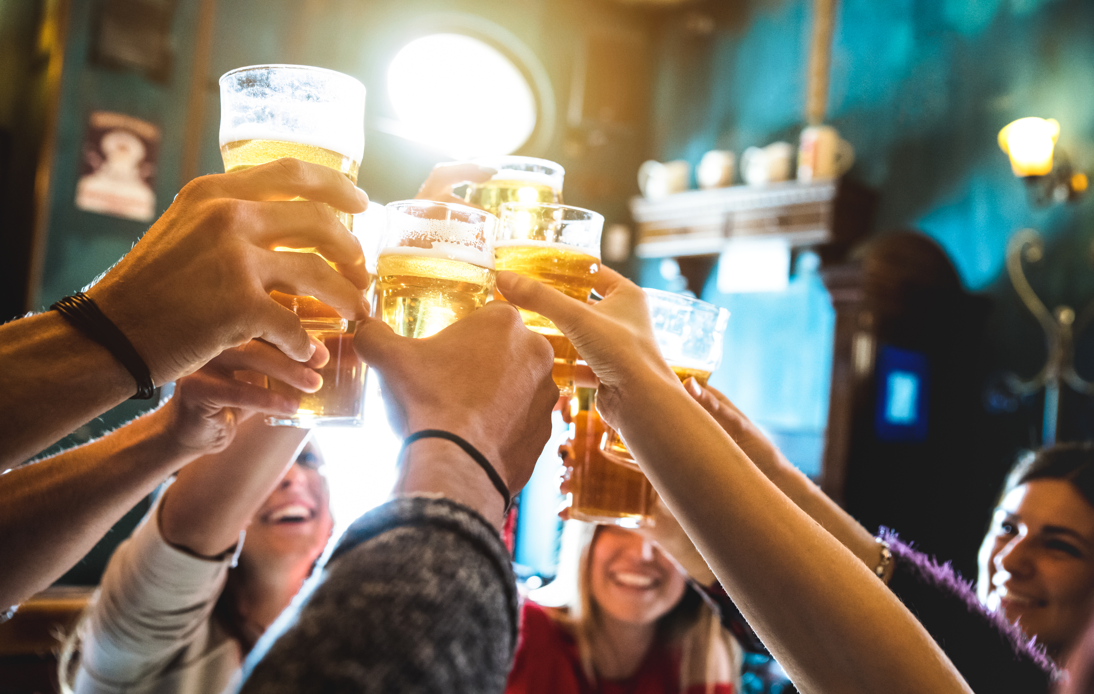 Are You More of a Baby Boomer or a Millennial? Group of happy friends drinking and toasting beer at brewery bar restaurant   Friendship concept with young people having fun together at cool vintage pub   Focus on middle pint glass   High iso image