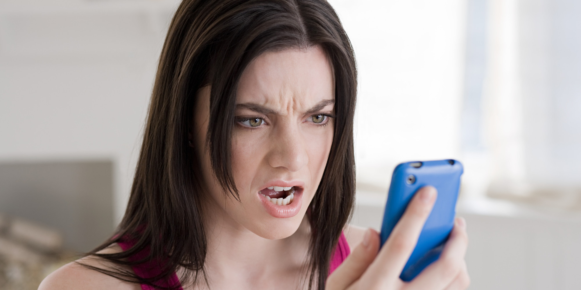 📱 Reply to These Texts and We’ll Tell You What Your Friends Think of You Angry woman looking at cellphone