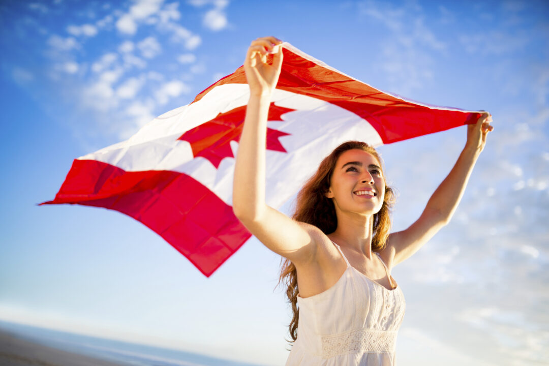 All Answers to This Trivia Quiz Are Numbers – Can You Get at Least 15/20? Woman Holding Canada Flag Against Sky