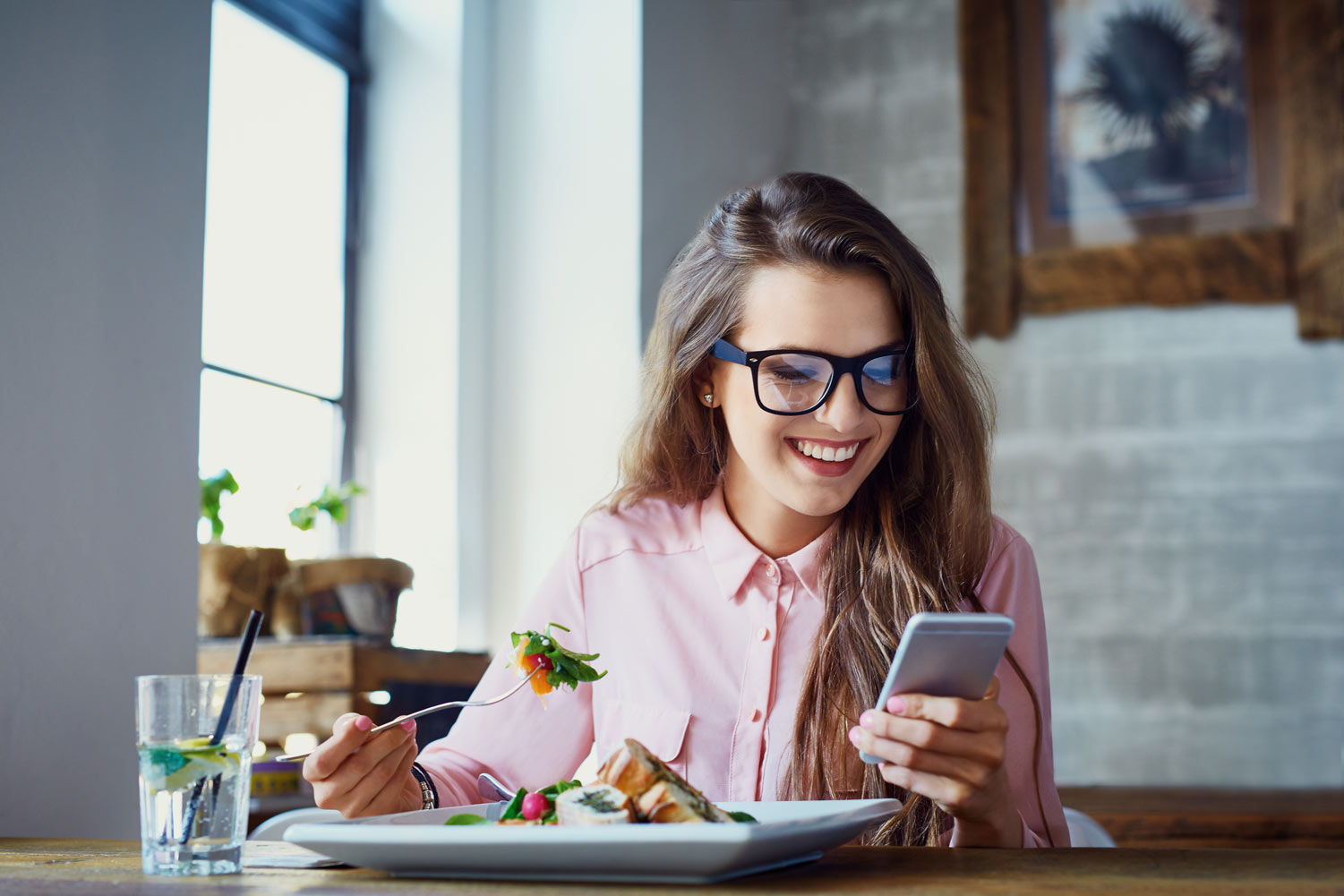 Woman Eating And Using Phone
