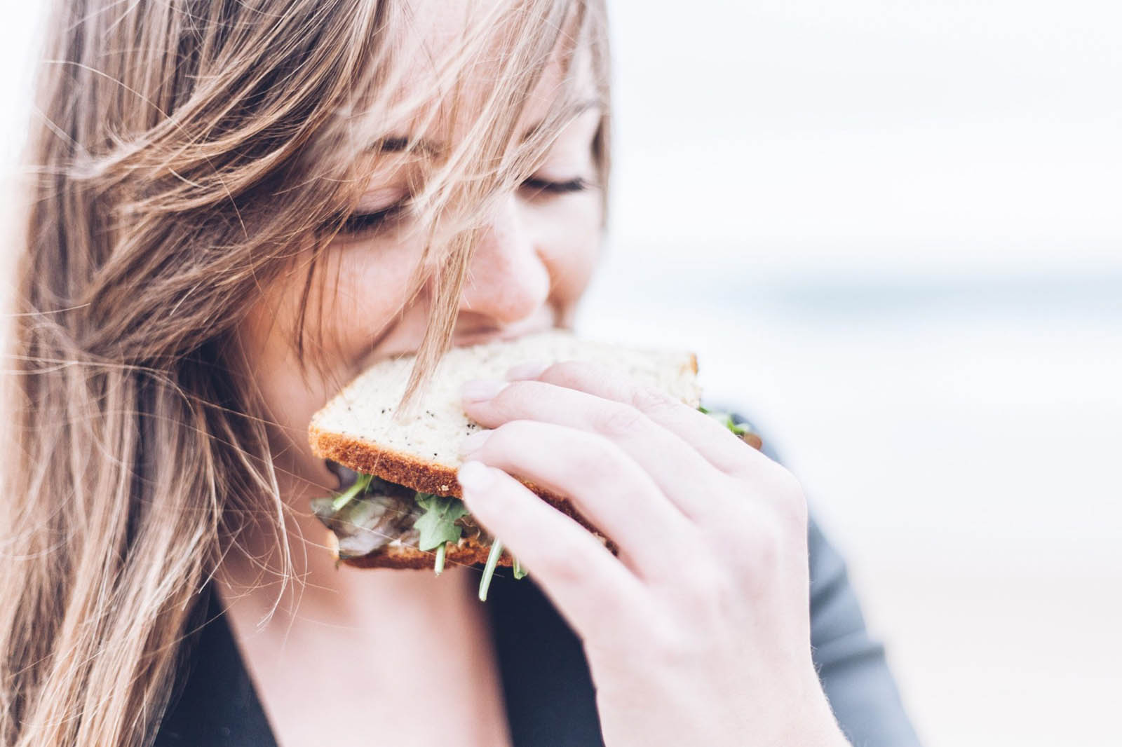 👶 Your Food Preferences Will Reveal Whether You’re a Youngest, Middle, Oldest, Or Only Child Woman Eating Sandwich