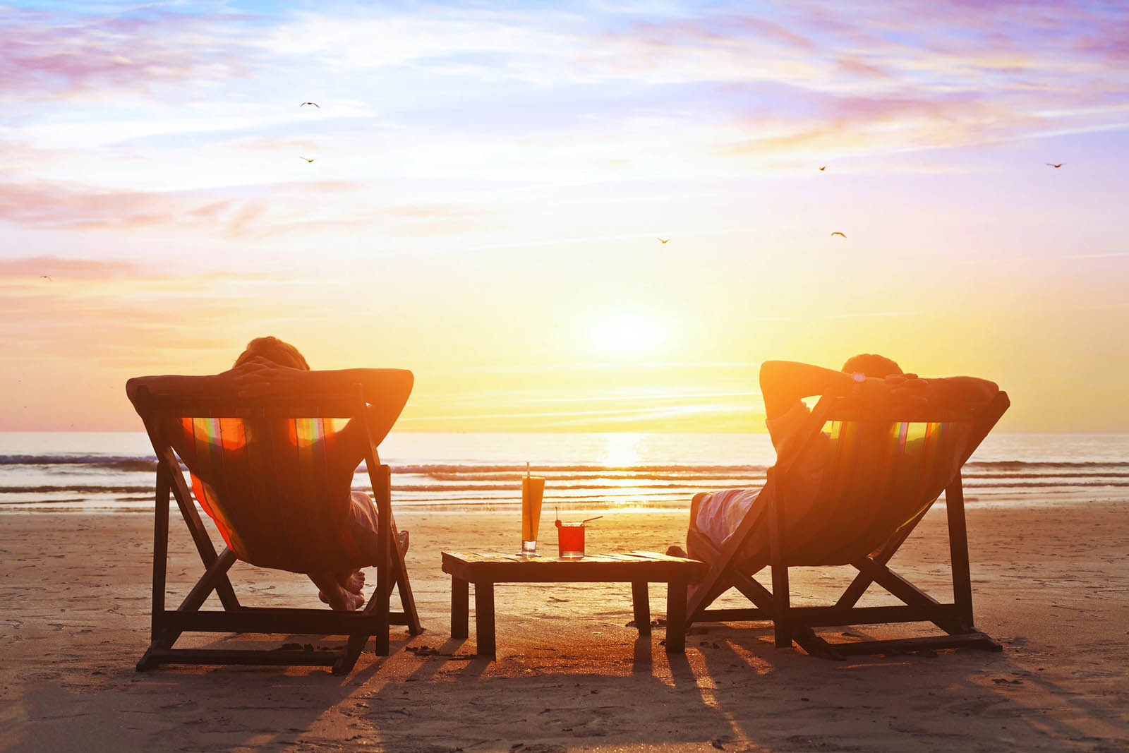 Which Part Of The US Are You From? Couple Relaxing On Beach At Sunset