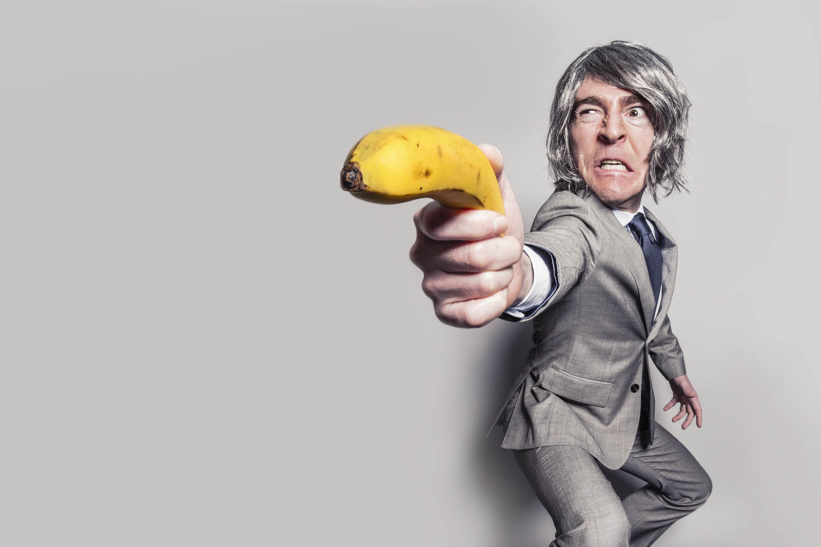Man In Business Suit Holding Banana Bizarre