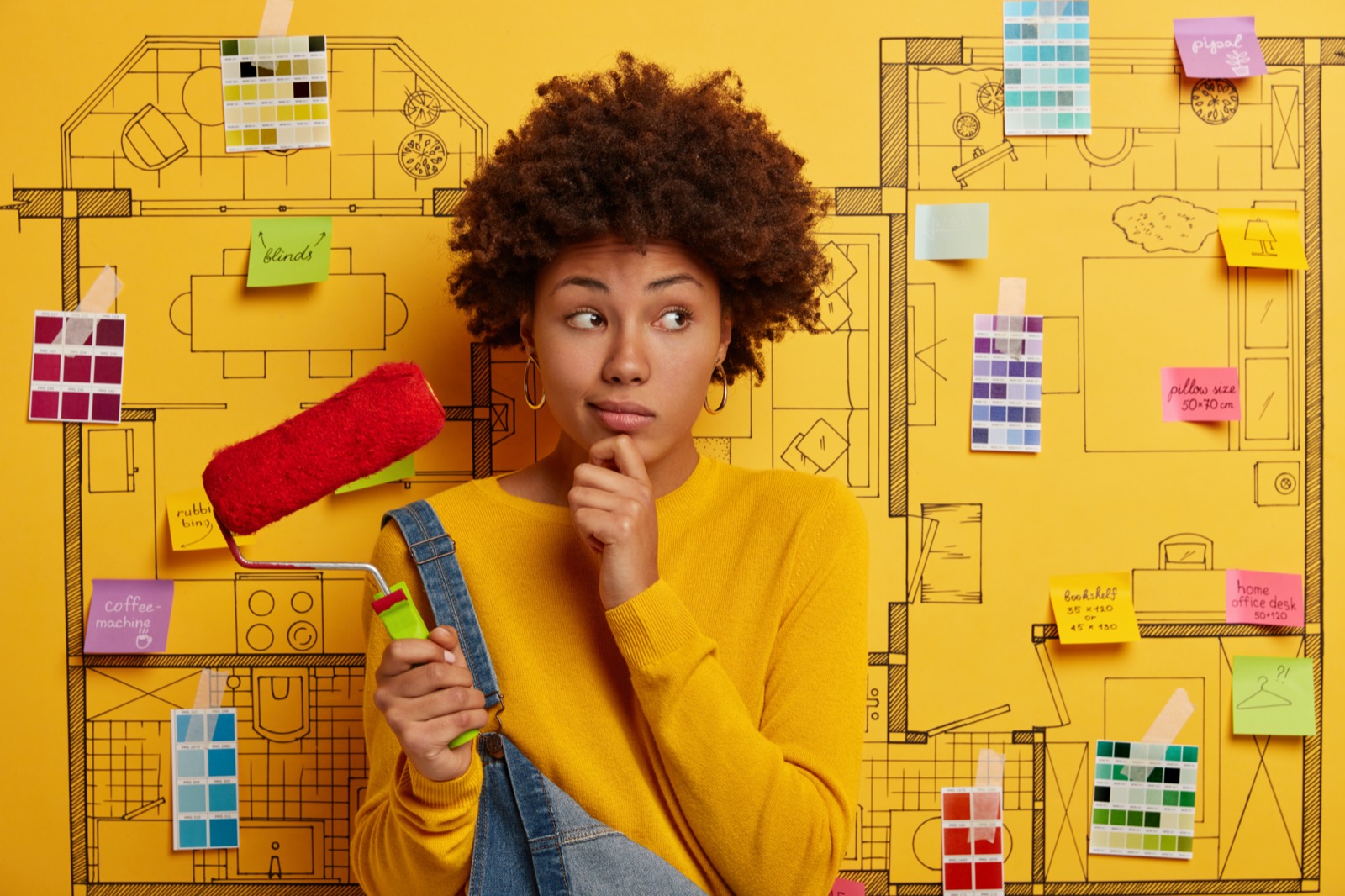 Can You Match These Definitions to the Words That Every 12-Year-Old Already Knows? House Redecoration Concept. Pensive Afro American Woman Holds Chin, Considers Something, Uses Paint Roller, Wears Yellow Sweater, Thinks About Repair, Poses Against Home Sketch With Sticky Notes