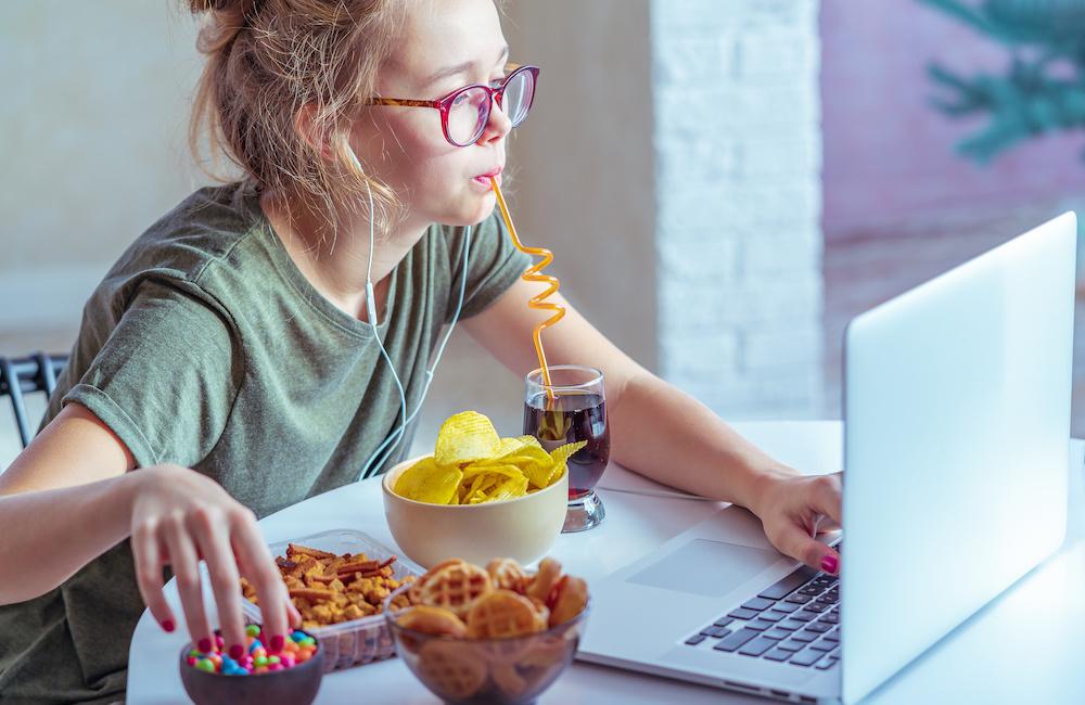 Eat Snacks All Day & I'll Give You Celeb Buddy Plus Mov… Quiz Girl Works At A Computer And Eats Fast Food. Unhealthy Food: Chips, Crackers, Candy, Waffles, Cola. Junk Food, Concept.