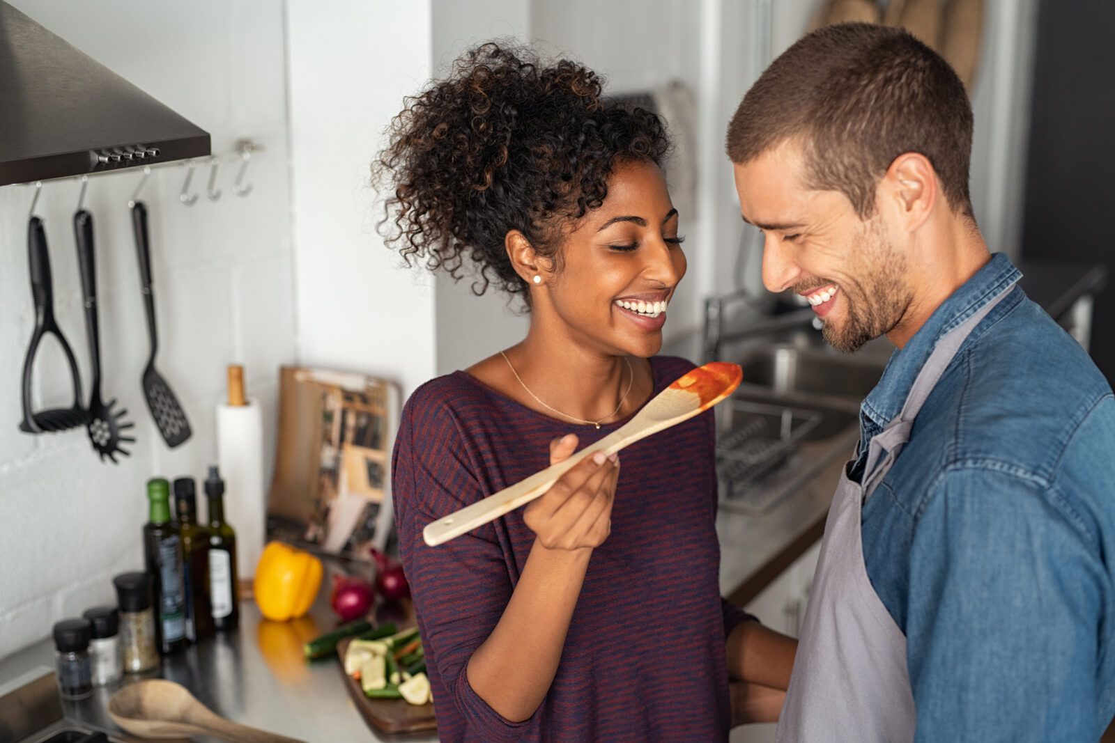 If You and Your Partner Have Done Most of These 🤢 “Gross” Things, You’ll Be Together Forever Multiethnic couple tasting food from wooden spoon
