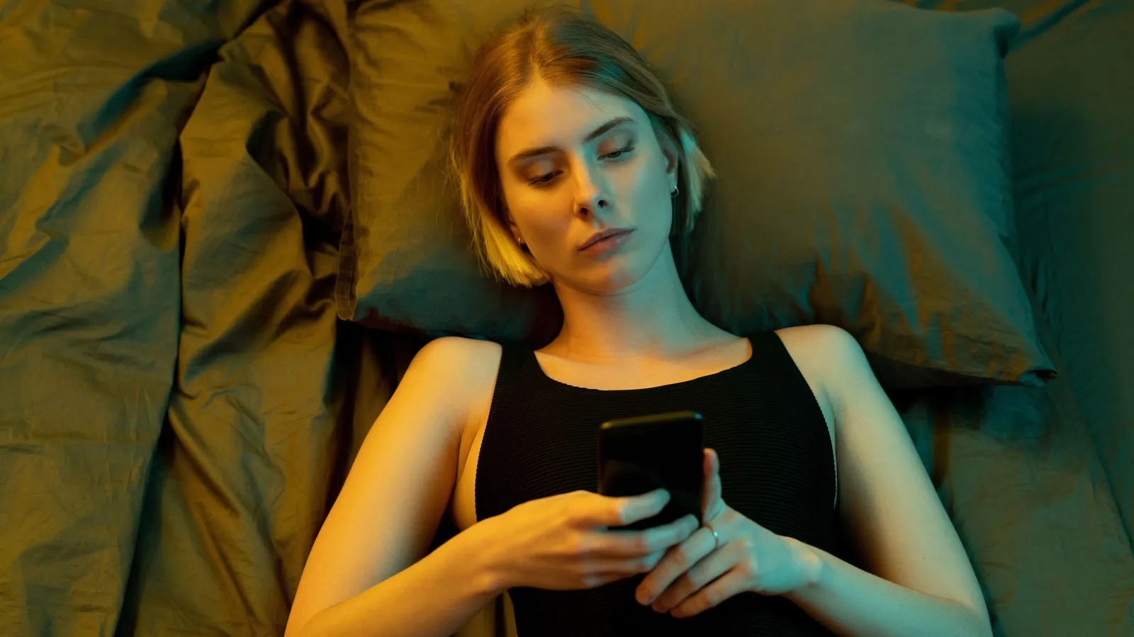 It’s Time to Find Out If You’re More Logical or Emotional With This “This or That” Game Woman using phone in bed