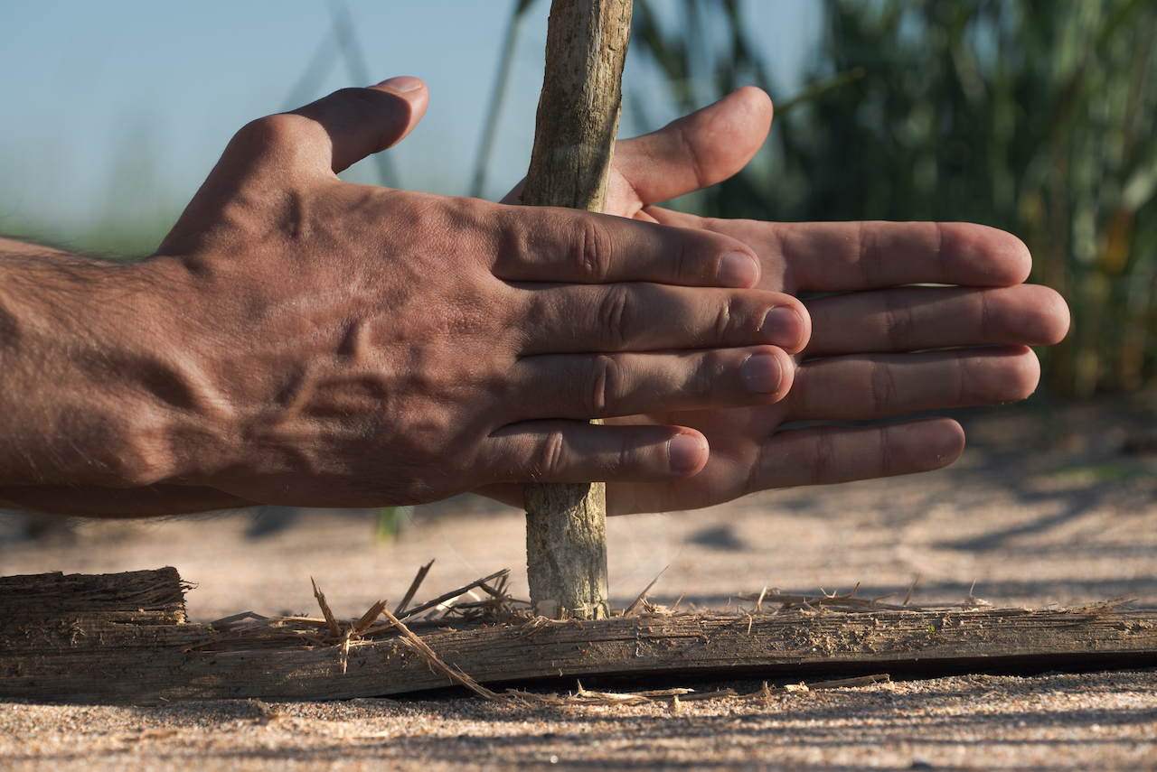 Ancient method for starting a fire in the wilderness with limited resources. Man in a survival situation trying to make a bonfire without matches and a lighter