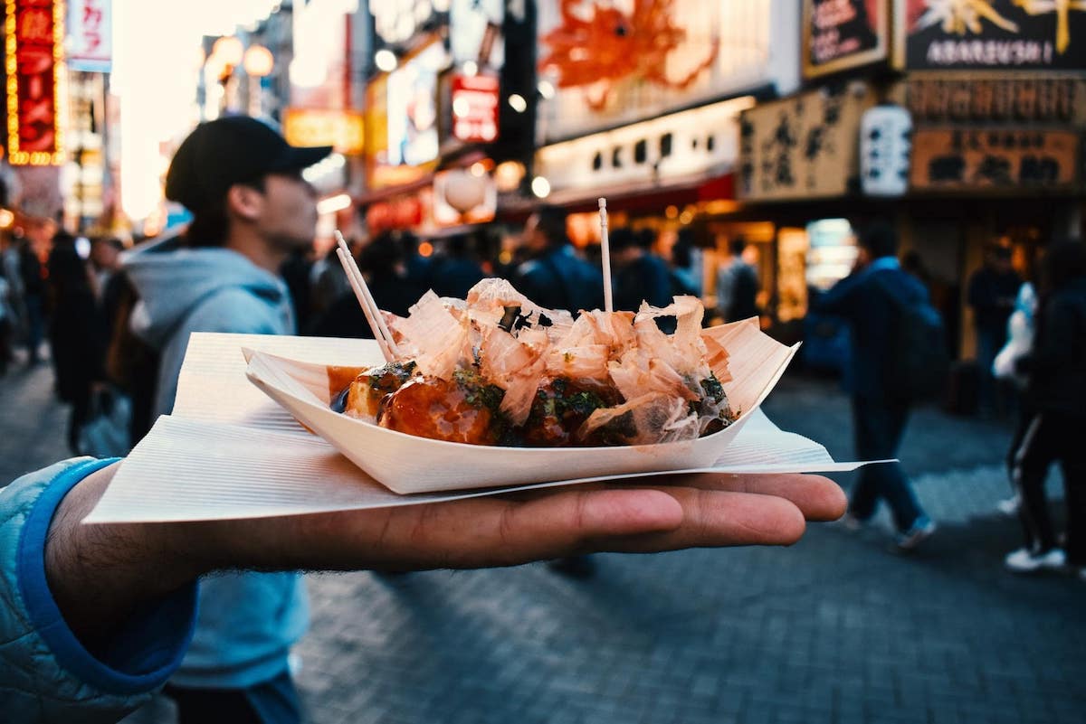 This Travel Quiz Is Scientifically Designed to Determine the Time Period You Belong in Eating Street Food Takoyaki Osaka, Japan