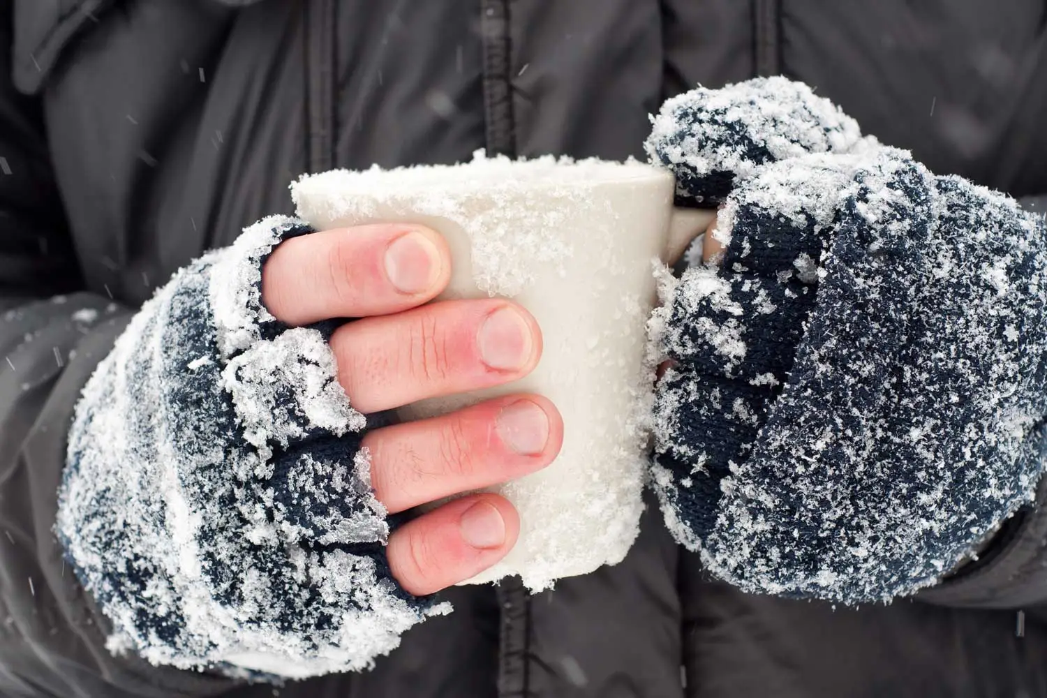 Cold hands holding cup